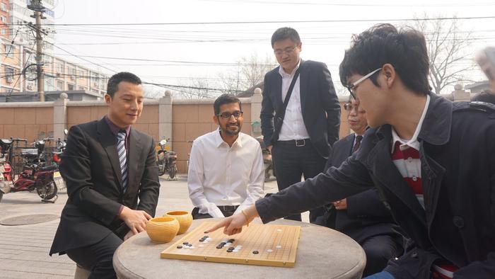 Le nouveau numéro 1 mondial du jeu de Go, le jeune chinois Ke Jie (tout à gauche) montre une attaque à Sundar Pichai, directeur de Google (assis au milieu). (Source: Google)